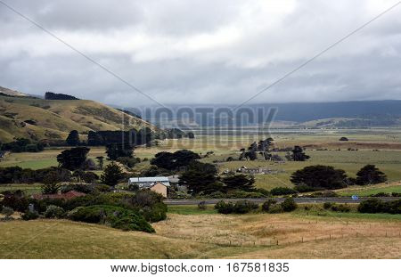 Broad panorama of the countryside in Victoria with green field in foreground. Grassy hills near Glenaire in Australia. Rural landscape near the forest in mountains. Hillside landscape.