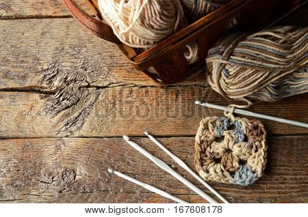 A top view image of a basket of crochet yarn and crochet hook.