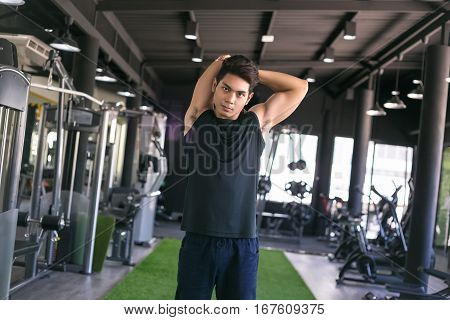 Portrait of a man doing stretching exercises at gym.