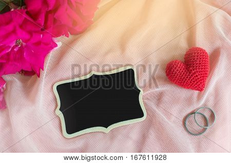 Red heart Rings rose and blackborad on pink fabric for Valentine's day or wedding background