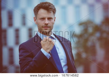 Close up portrait of handsome businessman showing fist