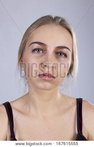Portrait of a young woman in a gloom on the gray background. Seven Deadly Sins