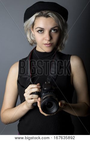 Female professional or amateur photographer holding a dslr camera. This photographic gear is used by both self employed artists and journalists or for tourism and hobbies.