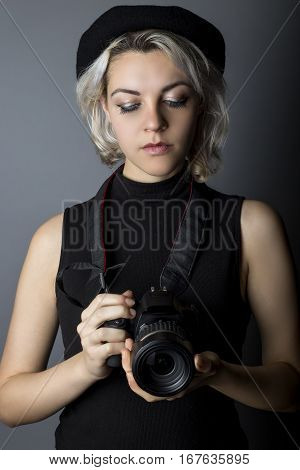 Female professional or amateur photographer holding a dslr camera. This photographic gear is used by both self employed artists and journalists or for tourism and hobbies.