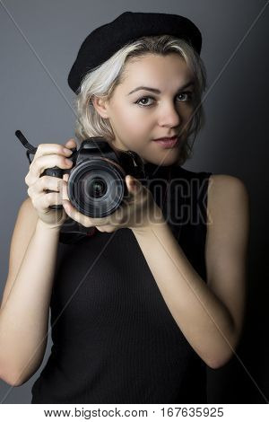 Female professional or amateur photographer holding a dslr camera. This photographic gear is used by both self employed artists and journalists or for tourism and hobbies.
