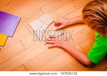learning math - little boy solving problem playing with puzzle