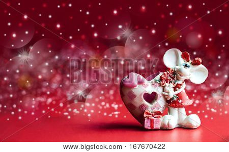 statuette of a little mouse with a bouquet of flowers on a red background