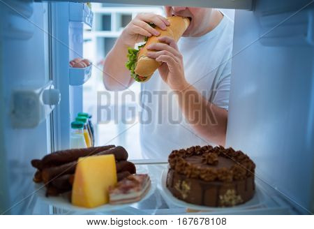 Overweight man on diet break diet with big sandwich roll