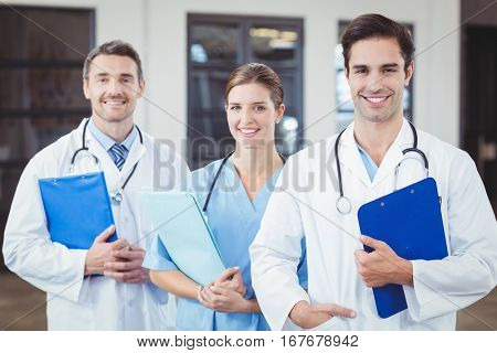Portrait of smiling docors standing in row at hospital
