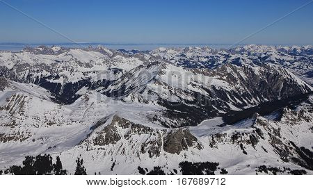 Winter landscape in the Swiss Alps. View from Glacier des Diablerets. Frozen lake Arnensee and snow covered mountain ranges.