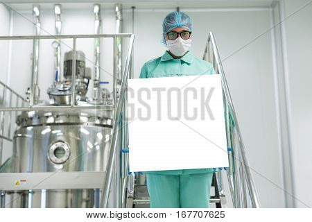 factory worker stand on metal stairs hold empty paper on front