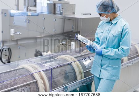 factory worker is checking readings of machine in chemical factory