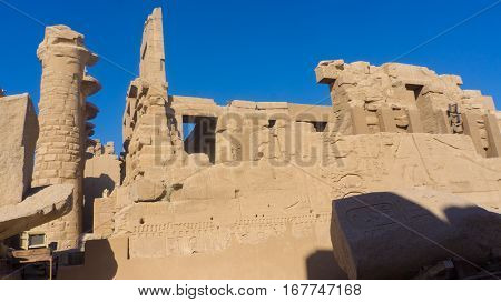 Ruins of an ancient temple of Egypt with statues and columns