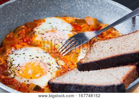 Delicious homemade shakshouka in a pan closeup. Traditional Middle East cuisine