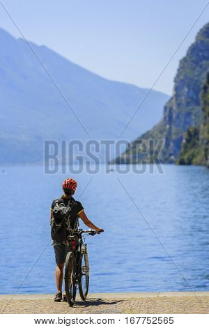 Mountain biking at sunrise woman over Lake Garda , Riva del Garda, Italy