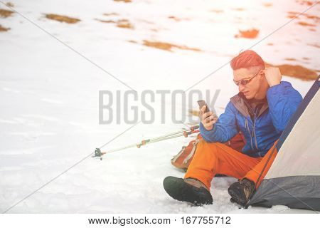 A Man Sits In A Tent In The Winter.