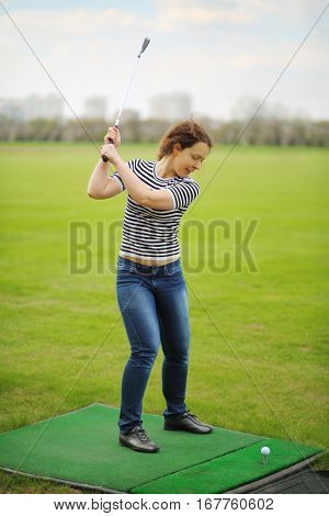 Woman with cammock plays golf on green golf course at spring day