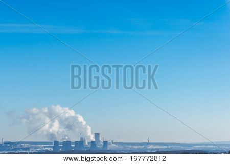 Nuclear power plant on the sky background. Cooling towers of NPP with smoke. Copy space for text.