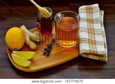 Cup of ginger tea with lemon and honey on wooden background. Natural fresh healthy drink. Spicy flu medicine.