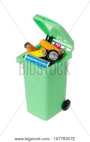 Old batteries in a green plastic recyling bin isolated on white background.