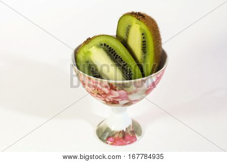 Two delicious halves kiwi in a Cup isolated on white background