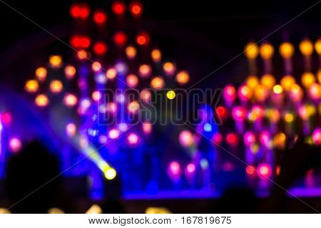 Abstract background with defocused bokeh of laser show in modern disco party night club - Concept of nightlife with music and entertainment - Image with powered colored halos and vivid bright lights