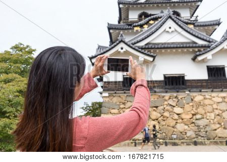 Back rear view of woman taking photo on Hikone Castle