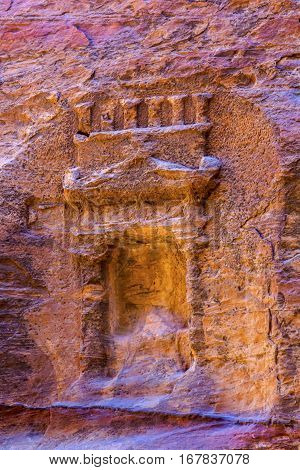 Small Rose Red Rock Tomb Outer Siq Canyon Petra Jordan. Built by the Nabataens in 200 BC to 400 AD. Rose Red canyon walls create many abstracts close up. Inside the Tombs the rose red can become blood red. Reds are created by magnesium in sandstone.