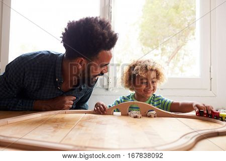Father And Son Playing With Toy Train Set