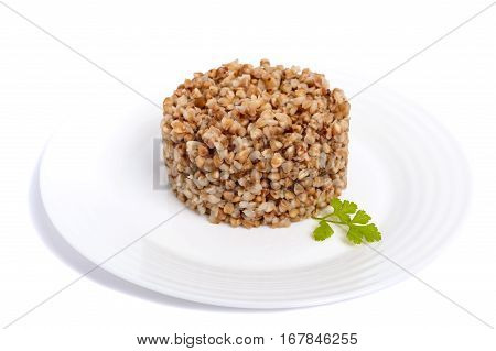 Buckwheat porridge in the form of a circle on a white plate on a white background. Dietary vegan Lenten dish. Isolate object.