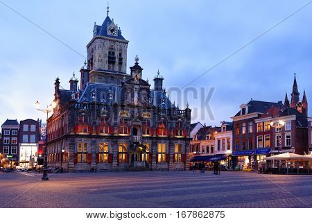 DELFT, NETHERLANDS - JANUARY 3, 2017: People on the Markt square in front of the City Hall. Built in 1620, it was heavily changed and was restored in the 20th century to its Renaissance appearance