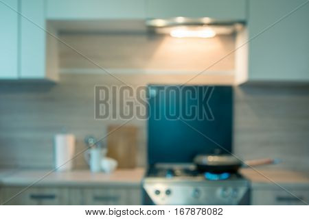 Blurred background. Modern kitchen with cooking on gas and space for you. Toned image.