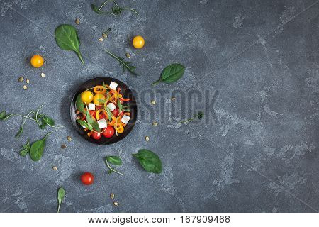 Spring salad with arugula feta cheese bell pepper and cherry tomatoes. Flat lay top view