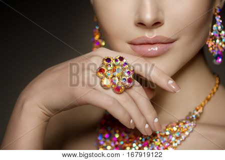 Diamond ring on the hand of a beautiful woman. Brilliant.  Antique old vintage earrings and ring. Jewelry on girl finger with lux manicure