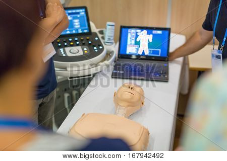 Team of medical doctor students learning to do advanced medical examination of patient with ultra sound scanner machine on ultrasound techniques workshop.