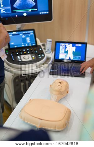 Team of medical doctor students learning to do advanced medical examination of patient with ultra sound scanner machine on ultrasound techniques workshop.