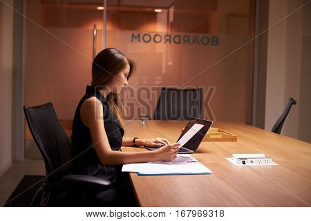 Young Asian businesswoman working alone late in an office