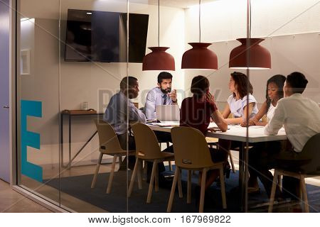 Corporate team at table in a meeting room cubicle, close up