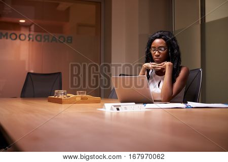 Young black businesswoman working late alone in office