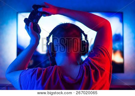 Gamer Or Guy-streamer At Home In A Dark Room With A Gamepad Playing With Friends In Networks In Vide