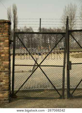 Auschwitz, Poland - March 30 2012: Gate In Concentration Camp Of Auschwitz With A Baby Carriage Behi
