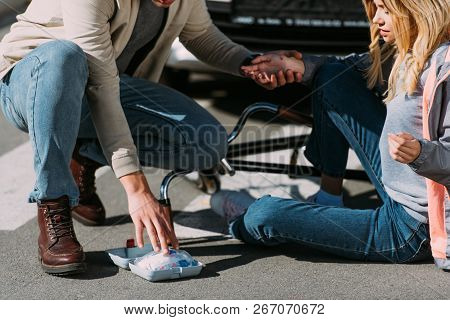 Partial View Of Man Getting First Air To Injured Woman After Car Accident On Road