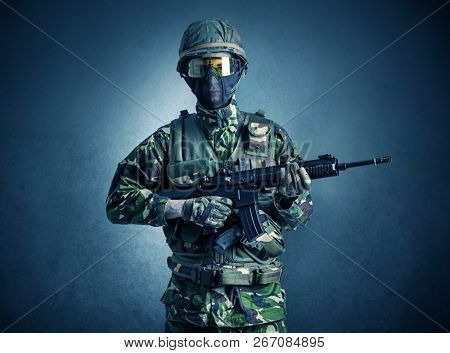 Soldier agent in a dark room with arms on his hand and gas mask