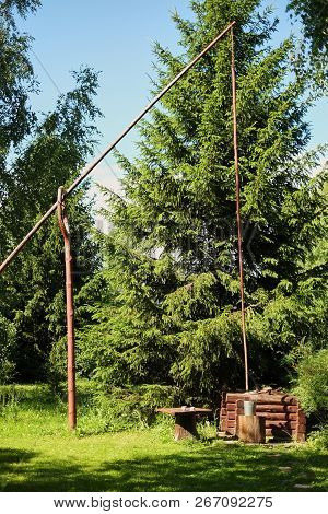 The Wooden Draw-well With The Crane In The Village. Russia