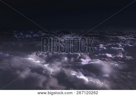 View From The Window Of The Plane To The Clouds At Night And Flashes Of Lightning