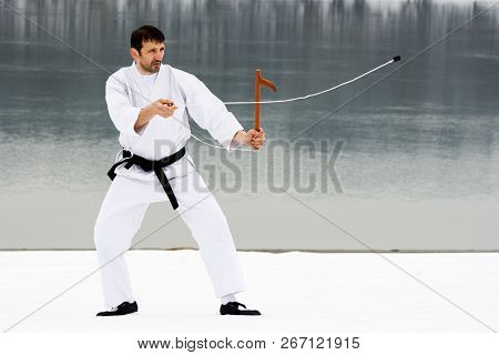 The Sporty Man In White Kimono Is Practicing Martial Arts With Kusarigama Japanese Wooden Weapon On 