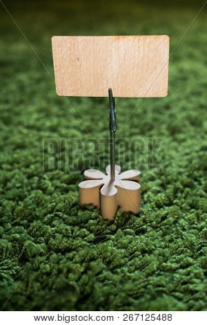 Clip Card Holder With Wooden Flower On Green Grass Carpet Holding A Natural Wooden Announcement Disp