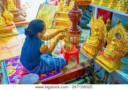 Mandalay, Myanmar - February 23, 2018: The Young Worker Glues Gold Leaves On The Statuette Of Lord B