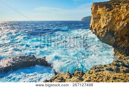The Foamy Waves At The Rocky Coast Of San Lawrenz With A View On Huge Limestone Cliffs At The Former