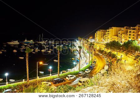 The Evening Walk Along The City Hill With A View On Fishing Harbour And Brightly Illuminated Seaside